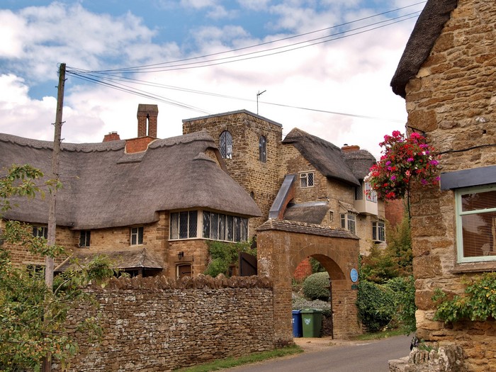 Thatched roof cottages and stone archway in a village