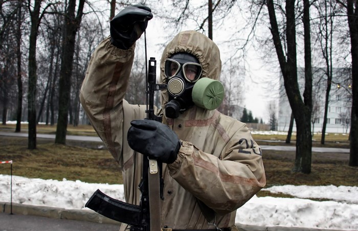 Soldier in gas mask and protective suit with rifle