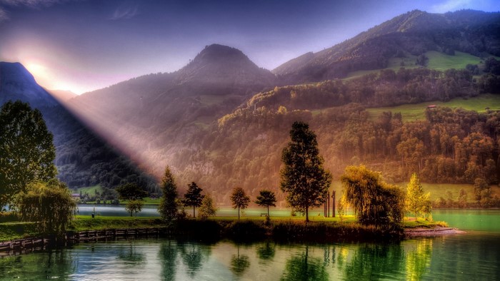 Sunbeams over a lake and mountains