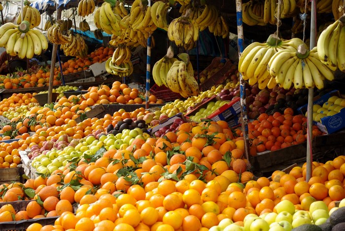 Fruit stand with bananas, oranges, and apples