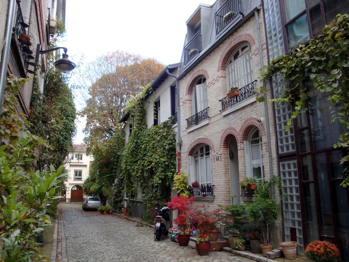 Cobblestone alley with houses and greenery in France
