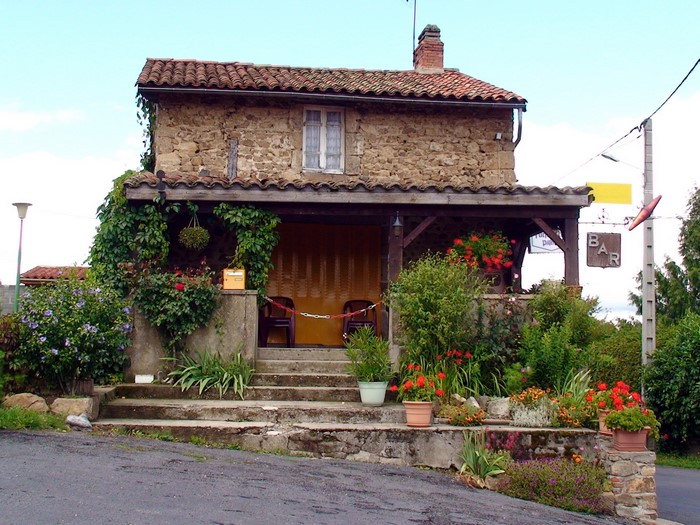 Stone house with a covered porch and flowers in France
