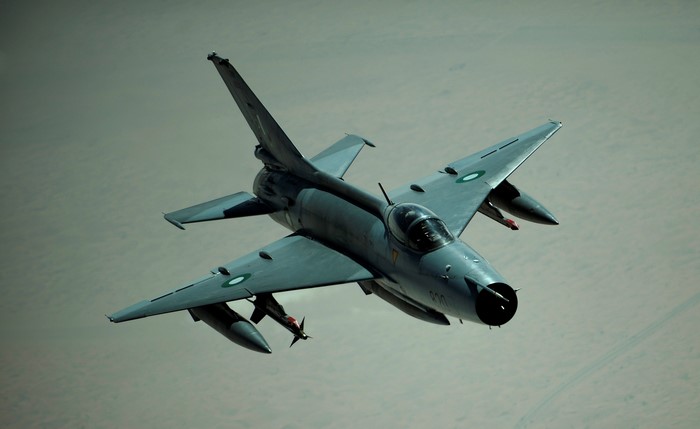 Fighter jet flying over desert landscape