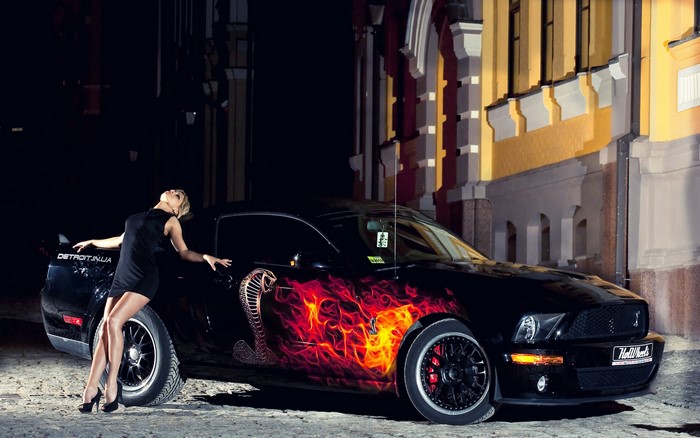 Woman posing with a custom Ford Mustang