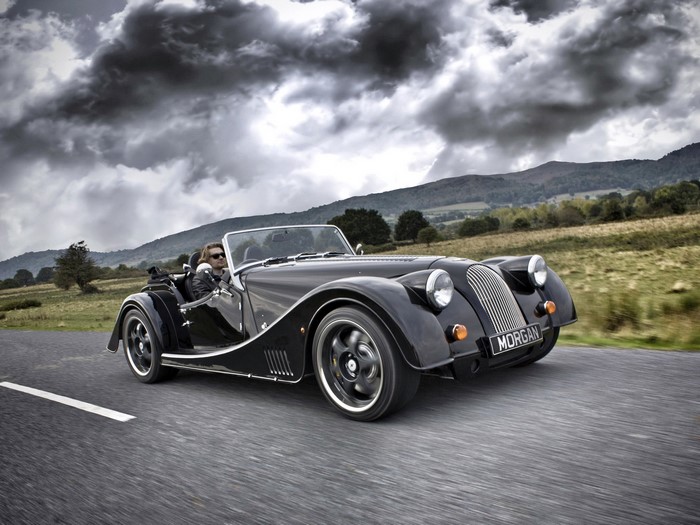 Black Morgan Plus 8 driving on a road