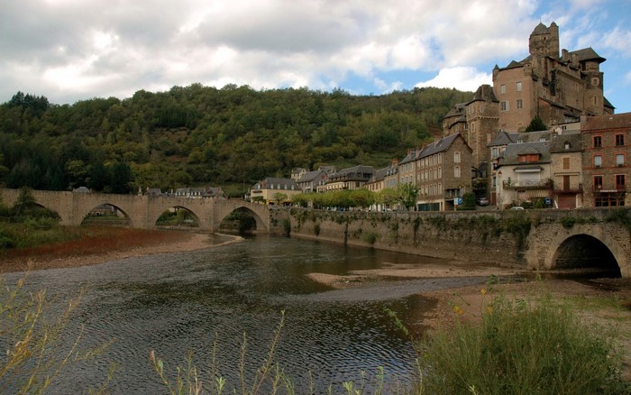 Castle Estaing, France, with a bridge over a river