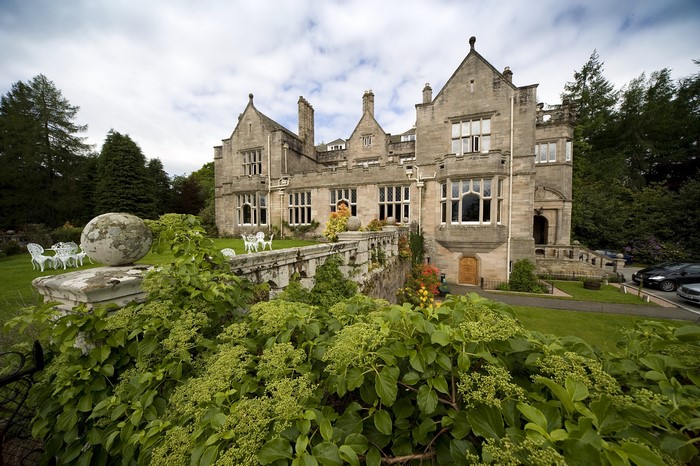 Stone castle with garden and parked cars