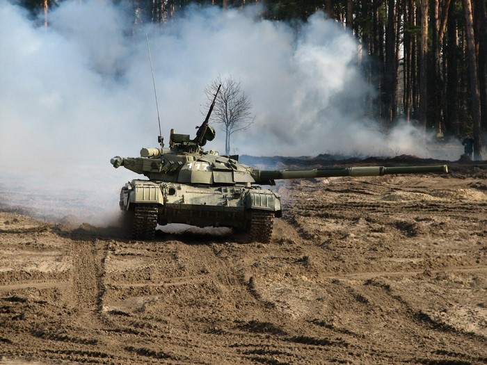 Tank moving through smoke and dirt