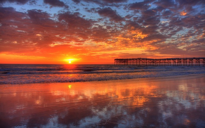 Sunset over the ocean with a pier