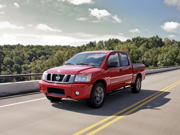 Red Nissan Titan Truck Driving on a Bridge