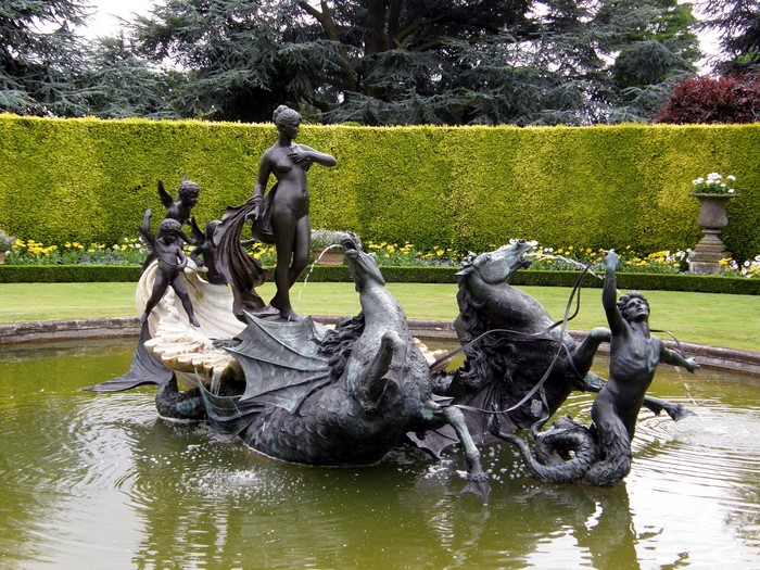 Bronze fountain sculpture of mythological figures in a garden pond