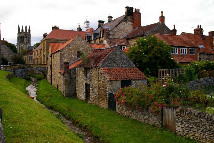 Village with stone buildings and a church tower in the UK