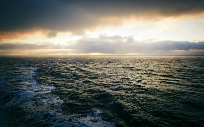 Open sea with dramatic clouds at sunset