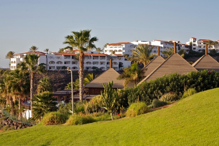 Resort buildings and palm trees on a hillside