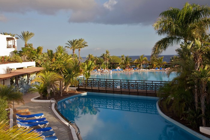 Resort swimming pools with palm trees and ocean view