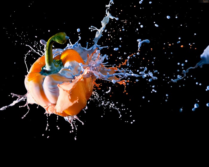 Orange bell pepper splashing with blue and orange paint