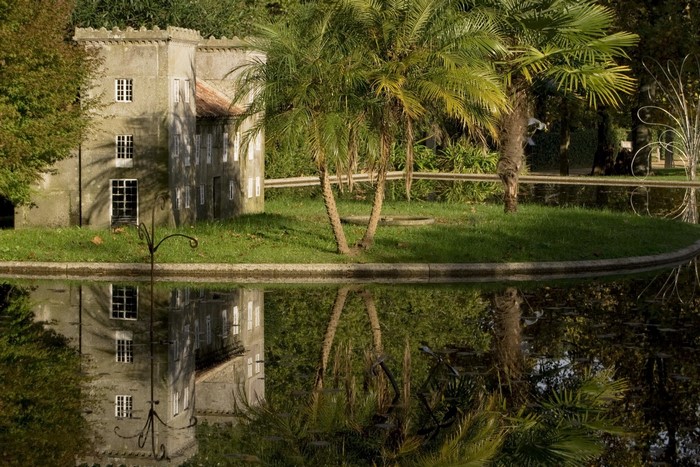 Miniature castle by a pond with palm trees