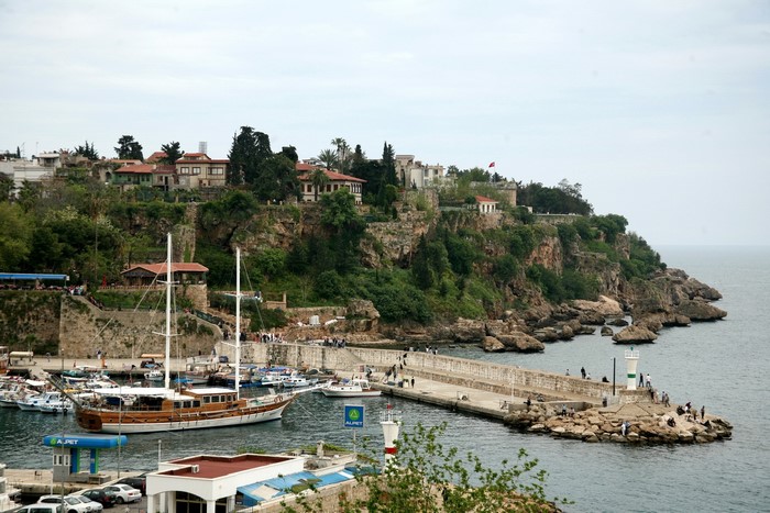 Harbor with boats and cliffside buildings in Turkey
