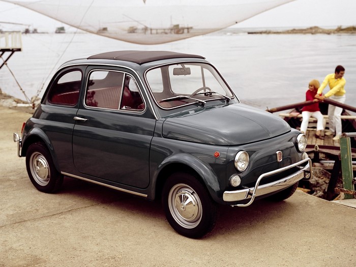 1968 Fiat 500 L parked by the water with people in a boat