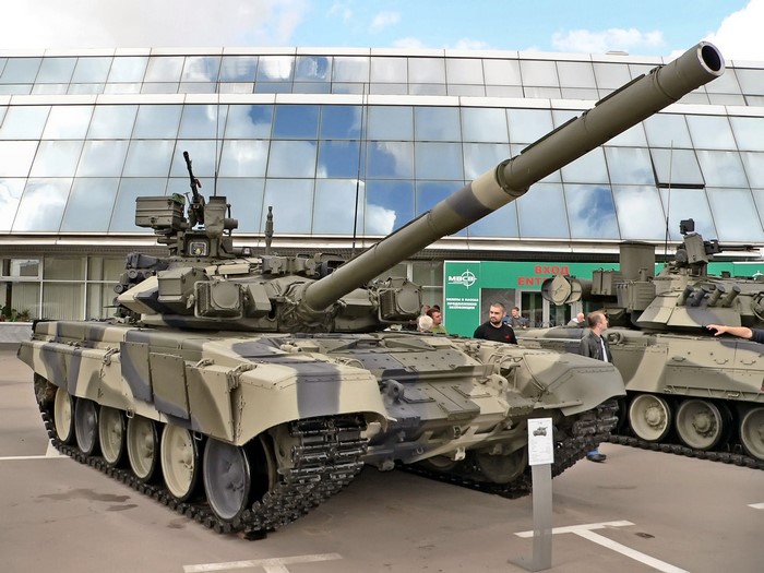T-90 tanks on display in front of a modern building