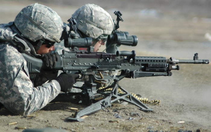 Soldiers firing a machine gun