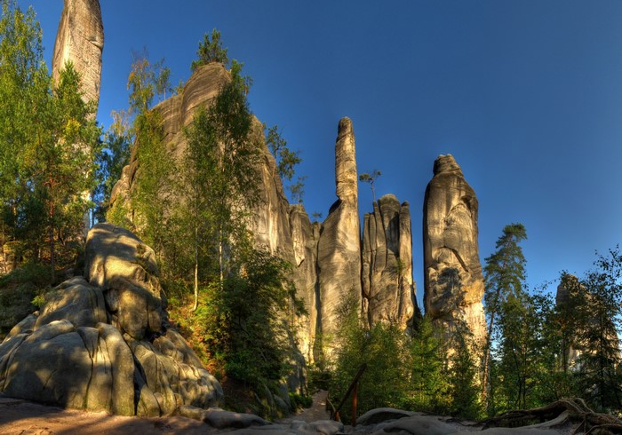 Rock formations and trees under a blue sky