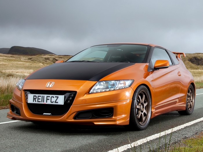 Orange Honda CR-Z with black hood on a road