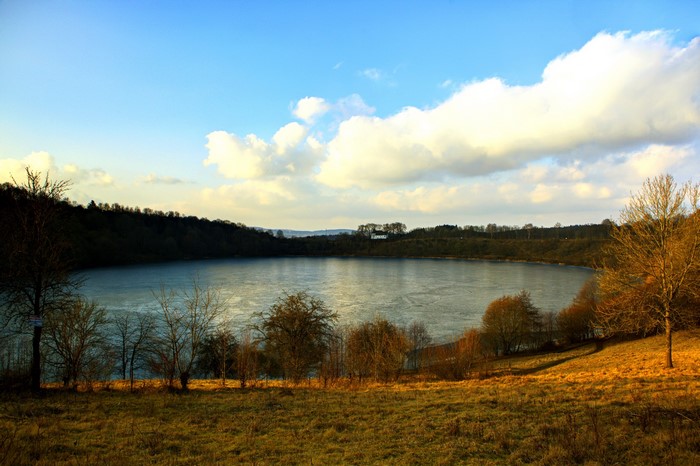 Frozen lake surrounded by trees and hills
