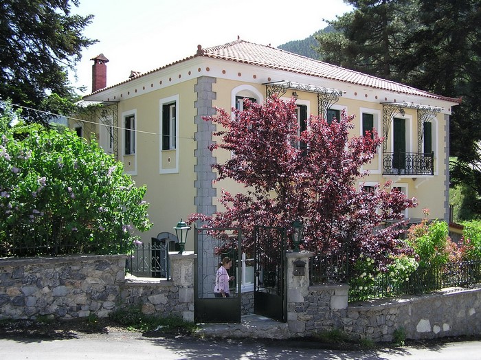 Yellow house with stone fence in Greece