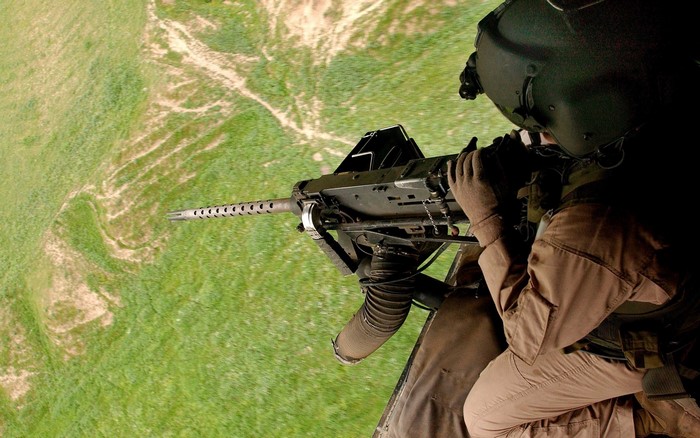 Soldier firing a machine gun from a helicopter