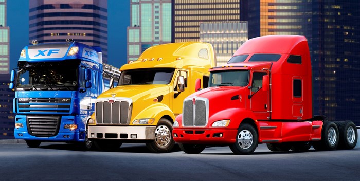 Three semi-trucks: DAF, yellow, and red