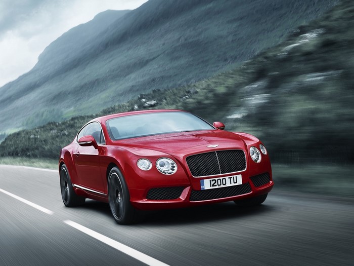 Red Bentley Continental GT driving on a road