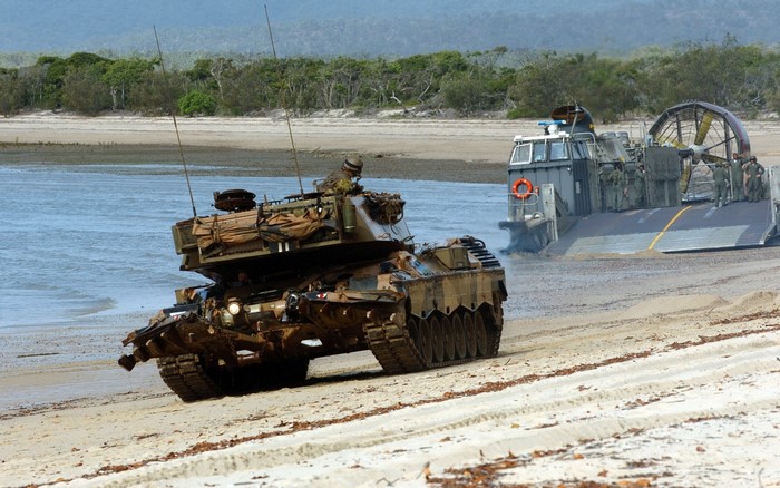Tanks on a beach with a hovercraft landing craft