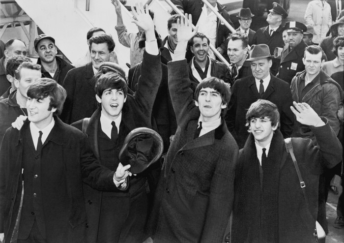 The Beatles waving to fans