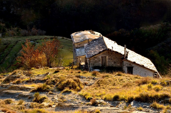 Stone house with damaged roof in a rural landscape