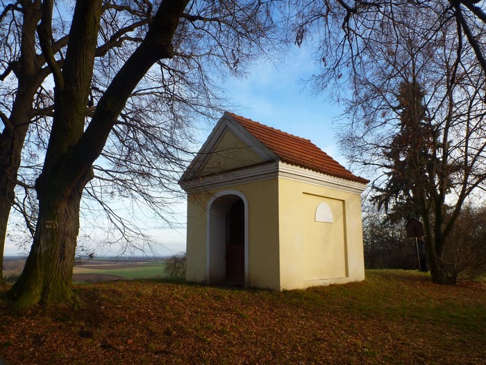 Small yellow chapel with a red roof in a park