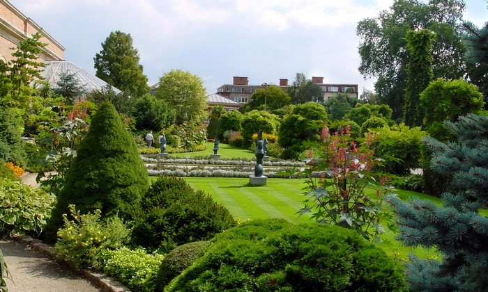 Sculptures in a manicured garden with a building