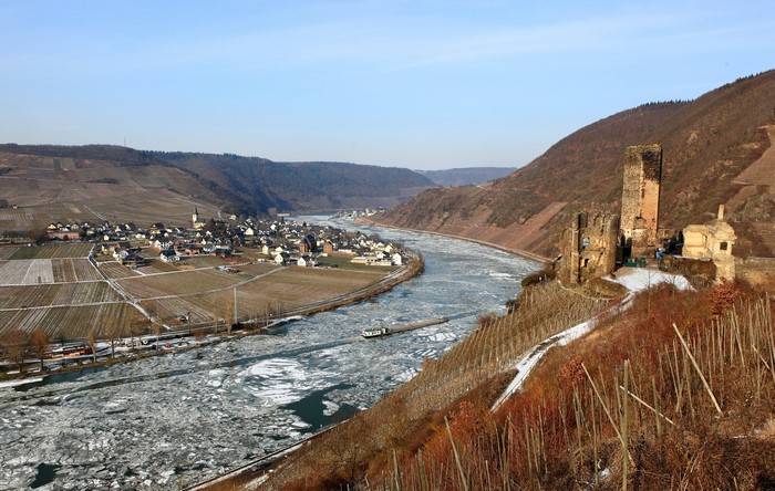 Ruins of a castle overlooking a frozen river and village
