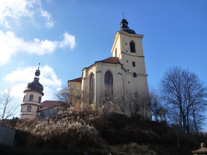 Church with a tower and a round tower on a hill