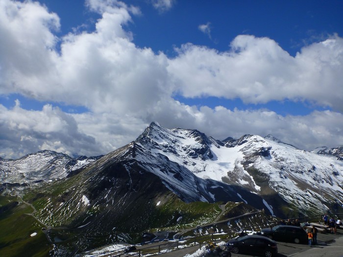 Snow-capped mountains with a winding road and cars