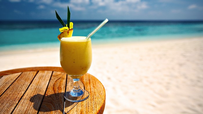 Yellow cocktail on a table at the beach