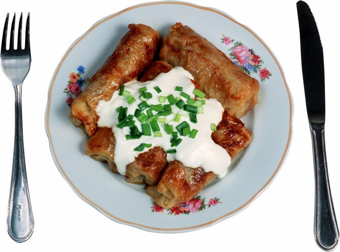 Cabbage rolls with sour cream and chives on a plate