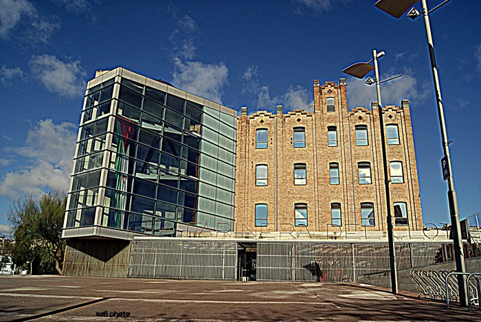 Modern glass building next to old brick building in Spain