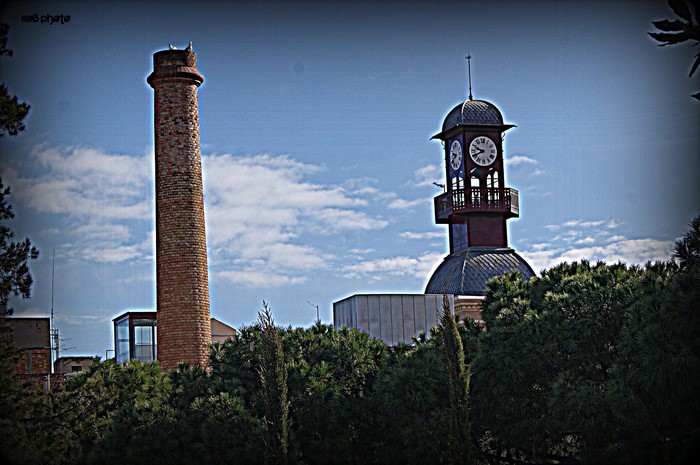Brick chimney and clock tower in Spain