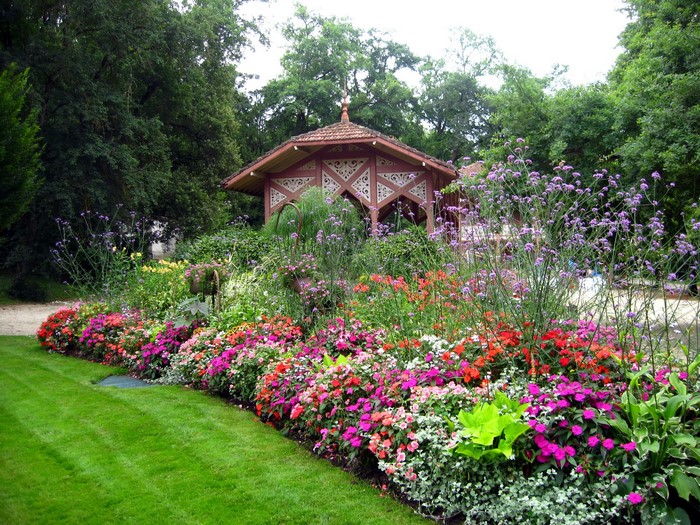 Gazebo in a park with colorful flower beds