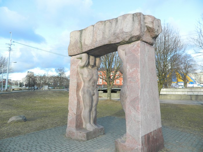 Monument with figures holding a stone arch in Kaliningrad