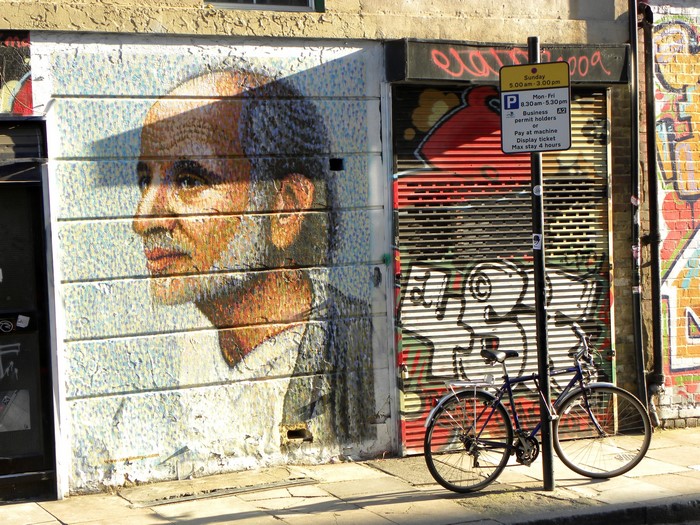 Graffiti and a portrait mural on a building