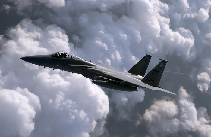 F-15 Eagle fighter jet flying through clouds