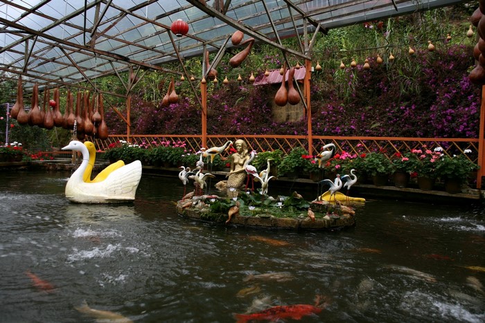 Garden pond with swan boat and mermaid statue