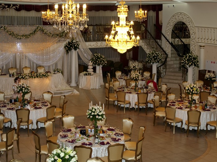 Wedding reception hall with ornate chandeliers and tables